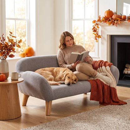 Femme lisant avec son toutou sur fauteuil pour chien décor automnal.